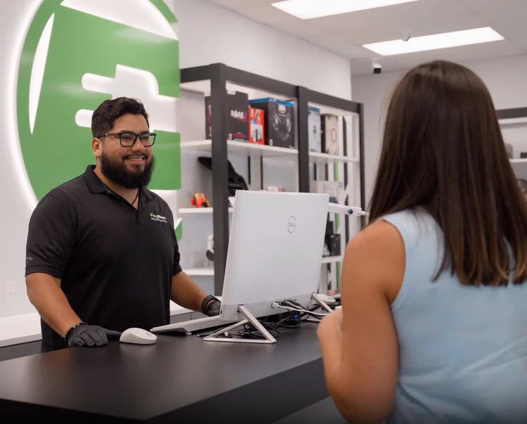 a man behind the counter smiling at a woman